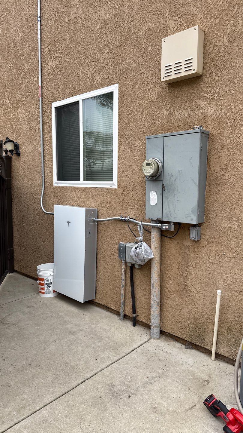 Tesla Powerwall 3 installed on exterior wall next to PG&E meter — Fresno, CA